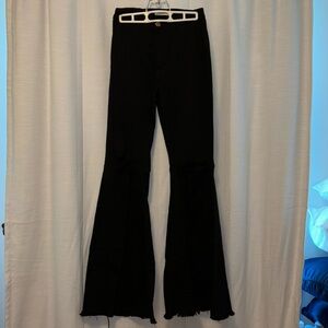 Vibrant MIU black flare jeans with rips in knees.
